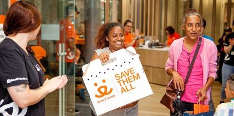 Woman holding a best friends cat carrier standing next to woman in pink top