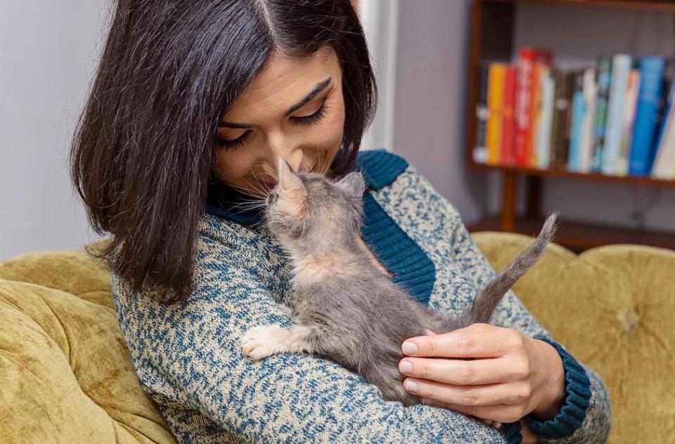 Woman cuddling with her kitten foster.
