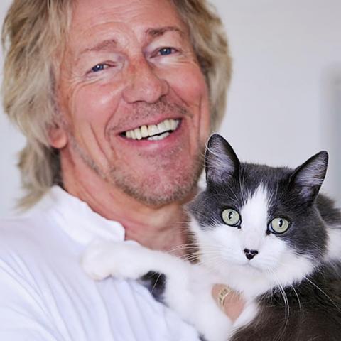 Gabriel de Peyer holding black and white cat