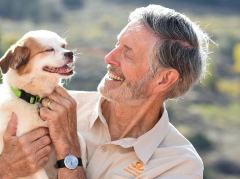 Gregory Castle smiling and holding a small dog