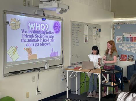 Students at Crestview Preparatory School beside a slide noting Best Friends as receiving donations