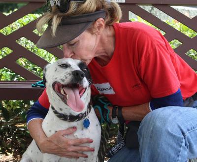 Humane Society of South Coastal Georgia volunteer kissing a dog on the head.