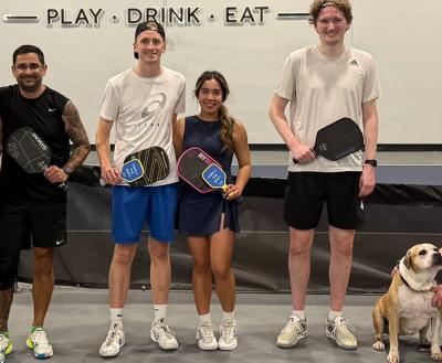 A group of people playing table tennis at a doggy day out program